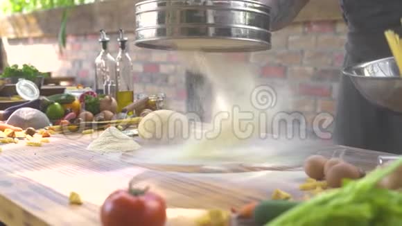 厨师用筛子把面粉粉倒进去揉面团人在做面团时在桌上筛面粉视频的预览图