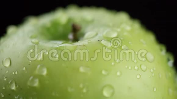 在视频中我们看到一个绿色的苹果水开始从顶部像波浪一样倾泻绿色的背景特写视频的预览图