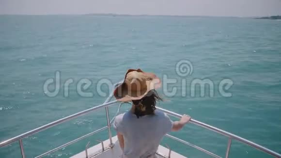 令人惊叹的后景拍摄快乐成功的女性旅行者享受豪华阳光游艇海上远足在船鼻前视频的预览图