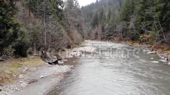 无人机沿着森林中一条山河的流水拍摄视频的预览图