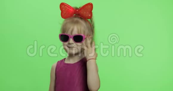女孩穿着紫色连衣裙跳舞头上戴着太阳镜和红色丝带色度键视频的预览图