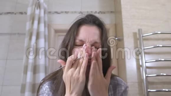 年轻女子捏出鼻子和脸上的粉刺视频的预览图