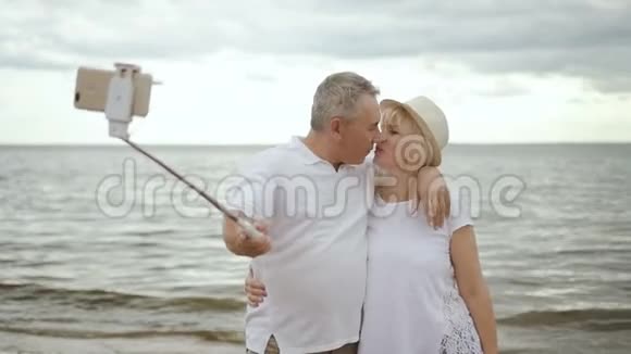快乐的成熟夫妇在海边接吻和自拍视频的预览图