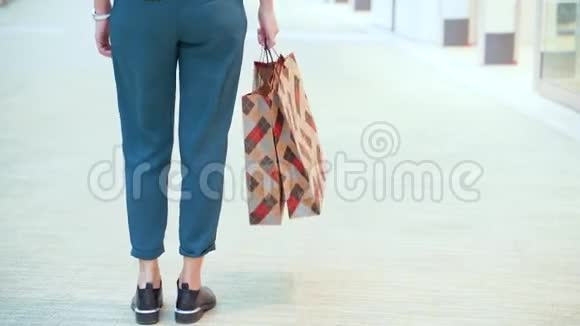 在商场拿包裹的年轻女人后面的景色视频的预览图