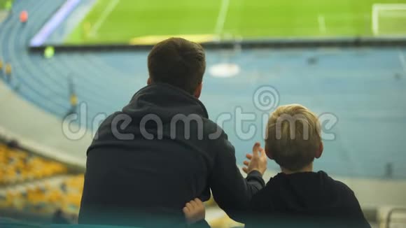 男孩和哥哥在体育场观看足球队训练情绪视频的预览图