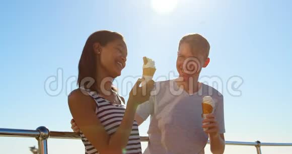 幸福的年轻夫妇在4k栏杆附近吃冰淇淋视频的预览图