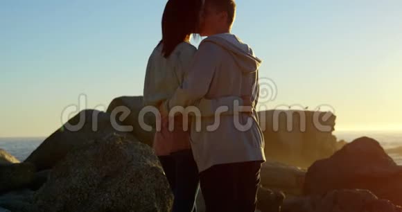浪漫的情侣在岩石海岸接吻4K视频的预览图