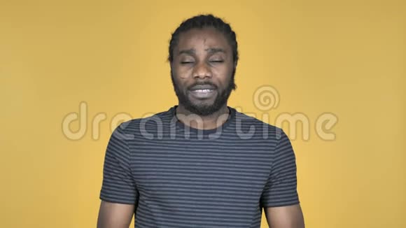 黄色背景下有头痛的非洲男子视频的预览图