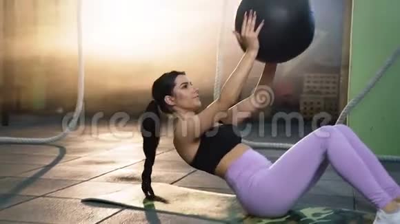 年轻健康的女人做腹肌运动与健美操球与有吸引力的运动男子视频的预览图