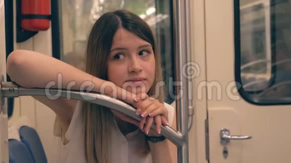 悲伤的年轻白种人女人在地铁里甩头搭栏杆视频的预览图