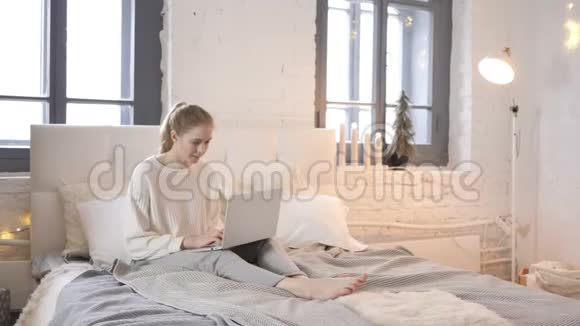 小女孩在床上坐着庆祝成功视频的预览图