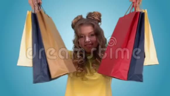 快乐的年轻女孩拿着多种颜色的购物袋微笑着视频的预览图