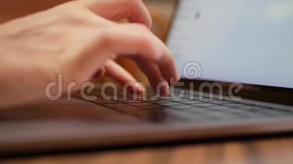 特写女性手在笔记本电脑键盘上打字在咖啡馆的笔记本电脑里工作的女人4k视频的预览图