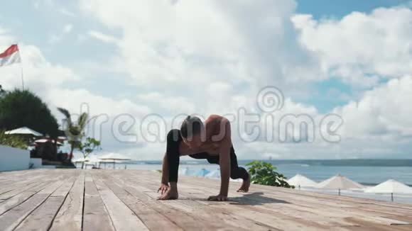 男人做瑜伽运动站在手上背景美丽视频的预览图