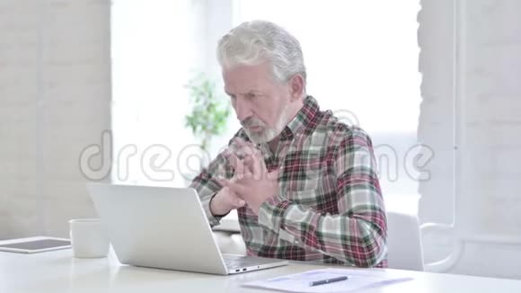 偶然的老人在笔记本电脑上思考和工作视频的预览图