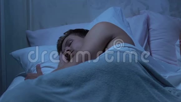 女人思考问题躺在床上丈夫平静地睡在旁边视频的预览图