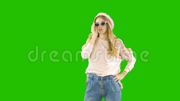 年轻的金发女郎穿着牛仔裤毛衣和眼镜带着情绪微笑和尖叫同时把眼镜戴在绿色上视频的预览图