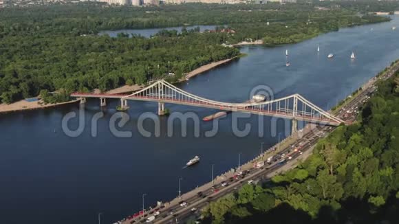 乌克兰基辅一艘货船与其他船只和城市在开阔的河流上的空中镜头视频的预览图