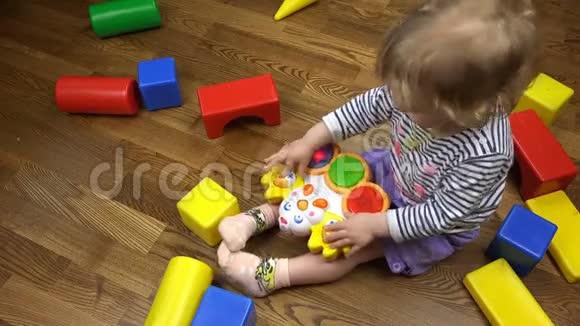卷曲的浅棕色女孩按下音乐玩具的按钮视频的预览图