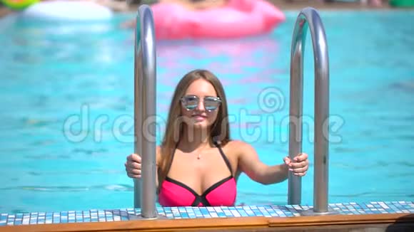 夏天美丽的年轻女子比基尼女孩在热带游泳池放松女人从游泳池里出来概念视频的预览图