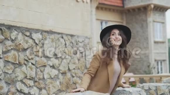迷人的闪亮的女人站在欧洲某处历史建筑的石阳台上女孩很欣赏视频的预览图