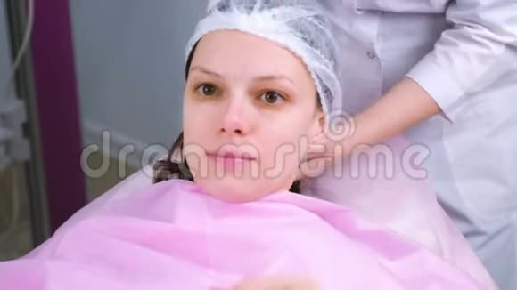 美容医生在手术前给病人戴上帽子视频的预览图