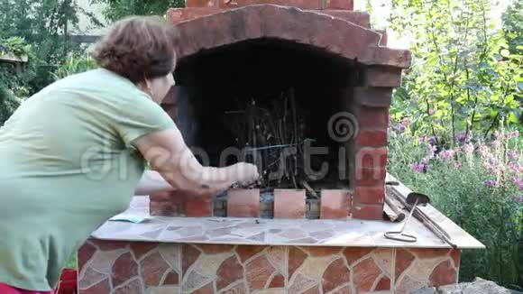 女人在花园壁炉里点着火视频的预览图