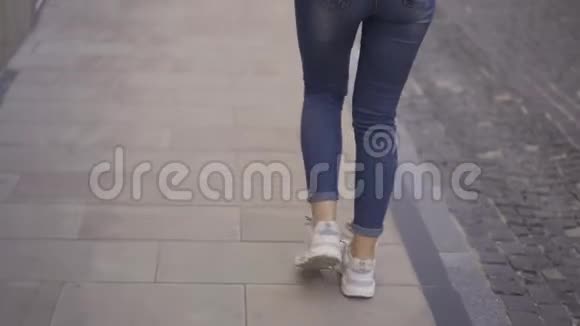 美丽的年轻女子走在城市的街道上快关门慢动作视频的预览图