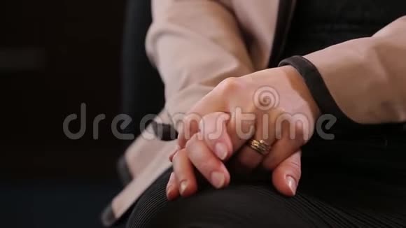 年轻紧张的女人的手在心理医生的治疗老年女性在沙发上搓手身体出现巨大问题视频的预览图