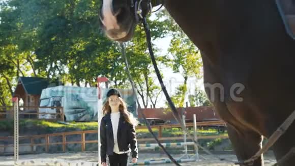 可爱的戴帽子的年轻女孩来了看着黑马的头摆姿势视频的预览图