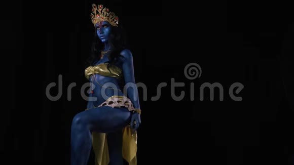 一位穿着金色衣服的印度女神卡莉站在黑色的背景上视频的预览图