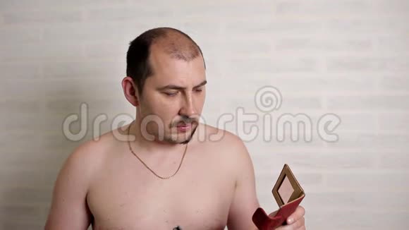 一个人用电动剃须刀刮大胡子一个人的特写肖像视频的预览图