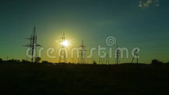 日落时分在乡村高压电力线的背景下运行云时间跨度视频的预览图