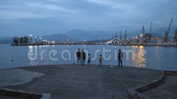 家人爸爸妈妈孩子和爷爷在港口码头上钓鱼和交谈视频的预览图