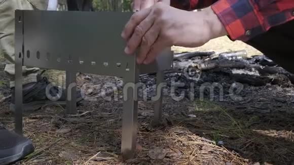 两个人在森林里集合了一个可折叠的小烧烤关门视频的预览图
