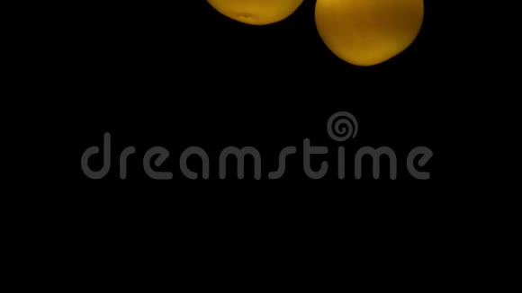 两个黄色的假名躺在透明的水底下黑色的背景视频的预览图