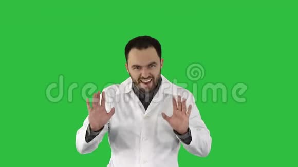友好的男性医学治疗师医生在绿色屏幕上看着镜头边走边说话彩色键视频的预览图