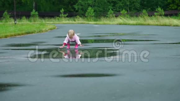 小女孩双手抱在水坑里视频的预览图
