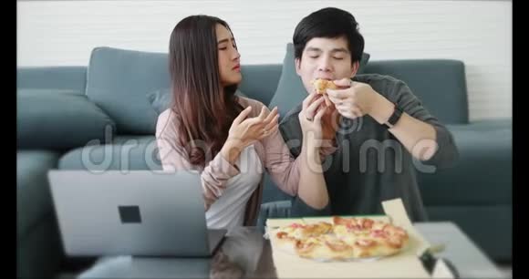 亚洲夫妇坐在一起吃披萨视频的预览图