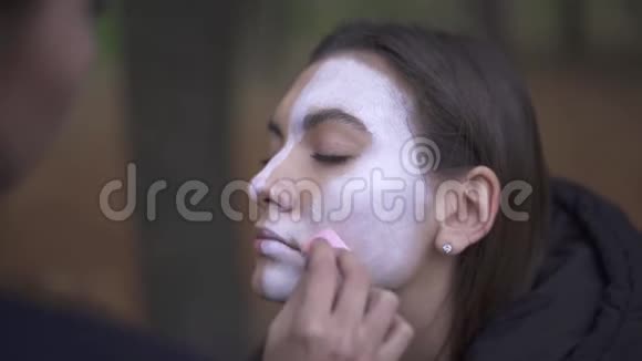 万圣节化妆师将化妆应用于女孩的脸视频的预览图