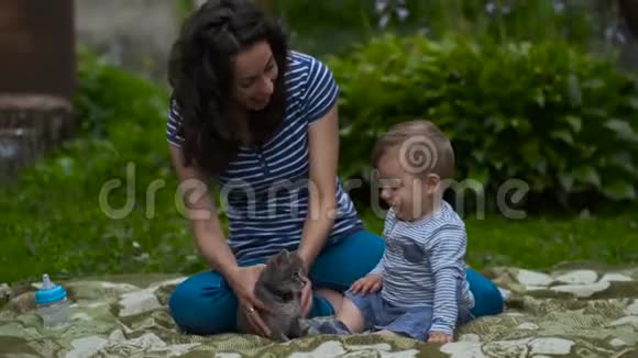 妈妈和孩子一起在花园里玩小灰猫视频的预览图