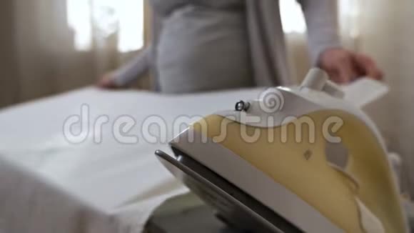 怀孕的家庭主妇抚摸一个年轻的孕妇在家里熨东西居家舒适视频的预览图