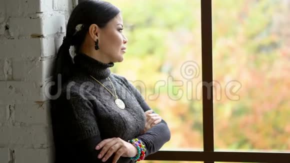 悲伤的女人呆在窗户附近反年龄概念视频的预览图