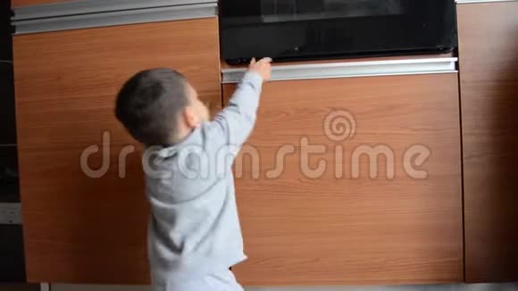 可爱的两岁男孩躲在厨房的橱柜下内置欧文视频的预览图