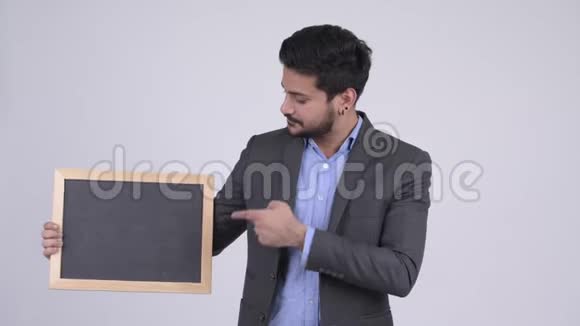 年轻快乐的留胡子的印度商人展示黑板并竖起大拇指视频的预览图