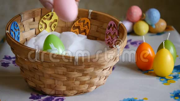 五颜六色的复活节彩蛋绿色黄色和粉红色的篮子男性手加一个粉红色和一个黄色的复活节彩蛋视频的预览图