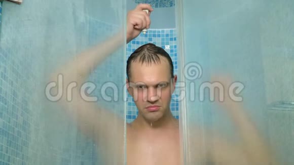 一个男人看着相机一边用洗发水洗头一边洗澡视频的预览图