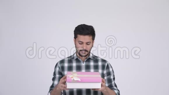 年轻快乐留胡子的印度男人打开礼盒视频的预览图