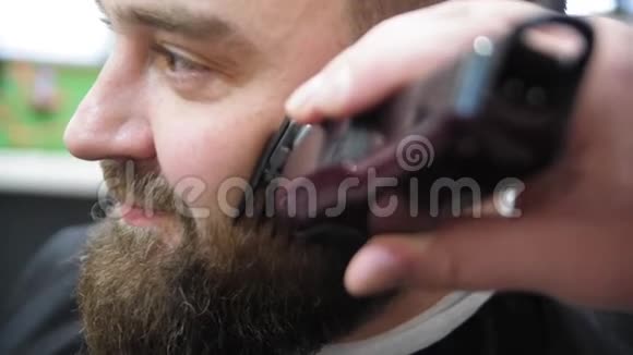 理发师用专业的胡须修剪在理发店的轻背景特写慢动作视频的预览图