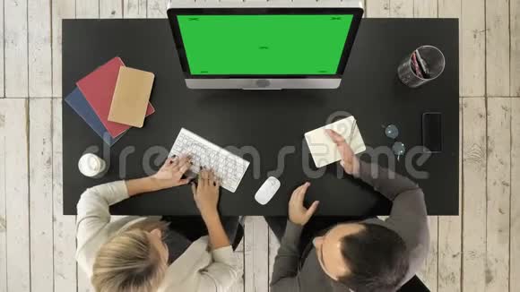 两位经理在电脑屏幕上讨论项目绿色屏幕模拟显示视频的预览图